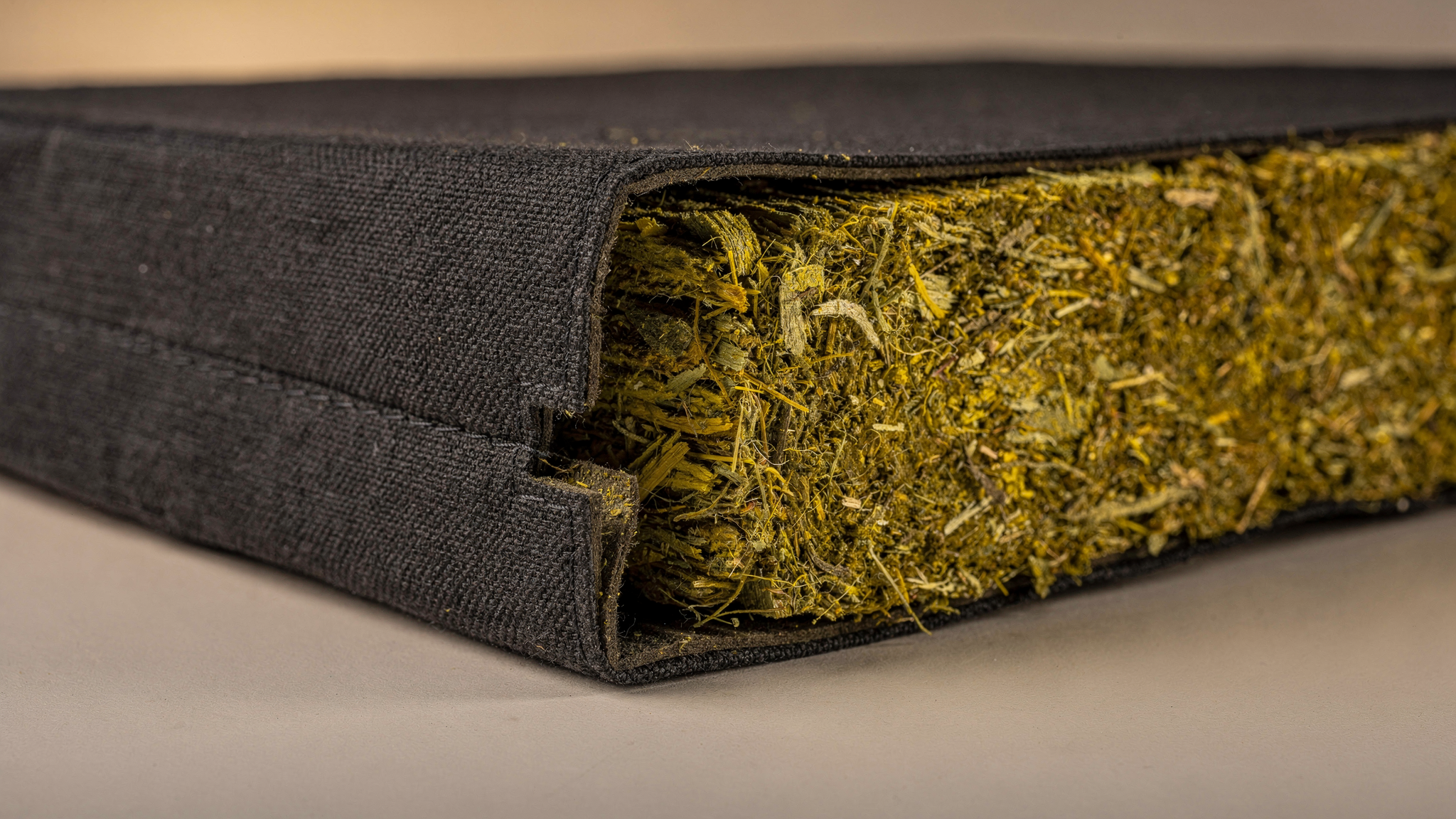 A fabric-wrapped acoustic panel cut open to reveal the fibrous mineral wool core